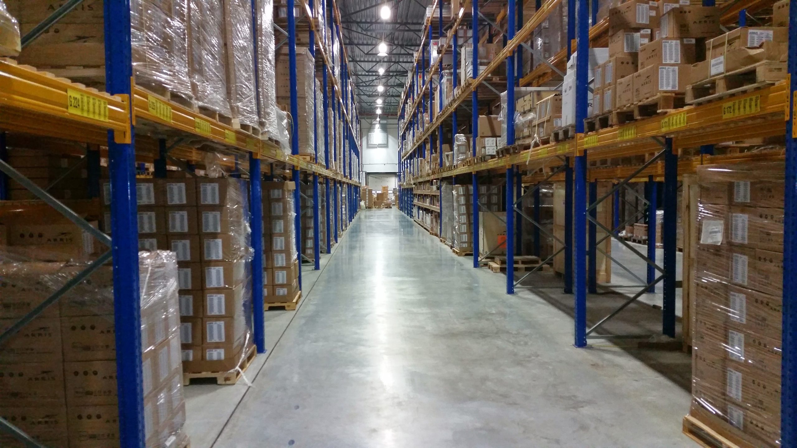 Allée d'entrepôt avec piles de cartons organisés