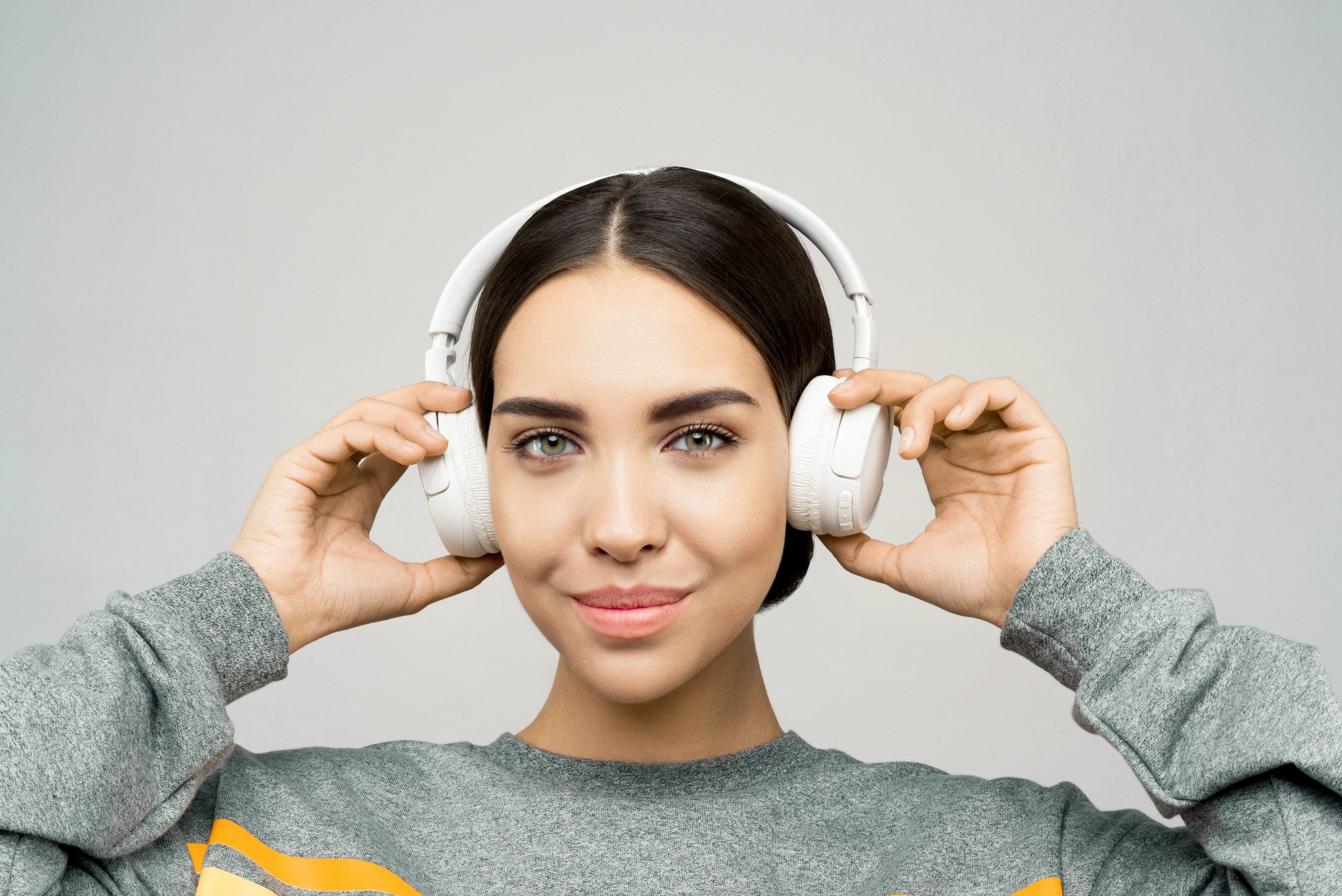 Jeune femme souriante écoutant musique casque relaxe