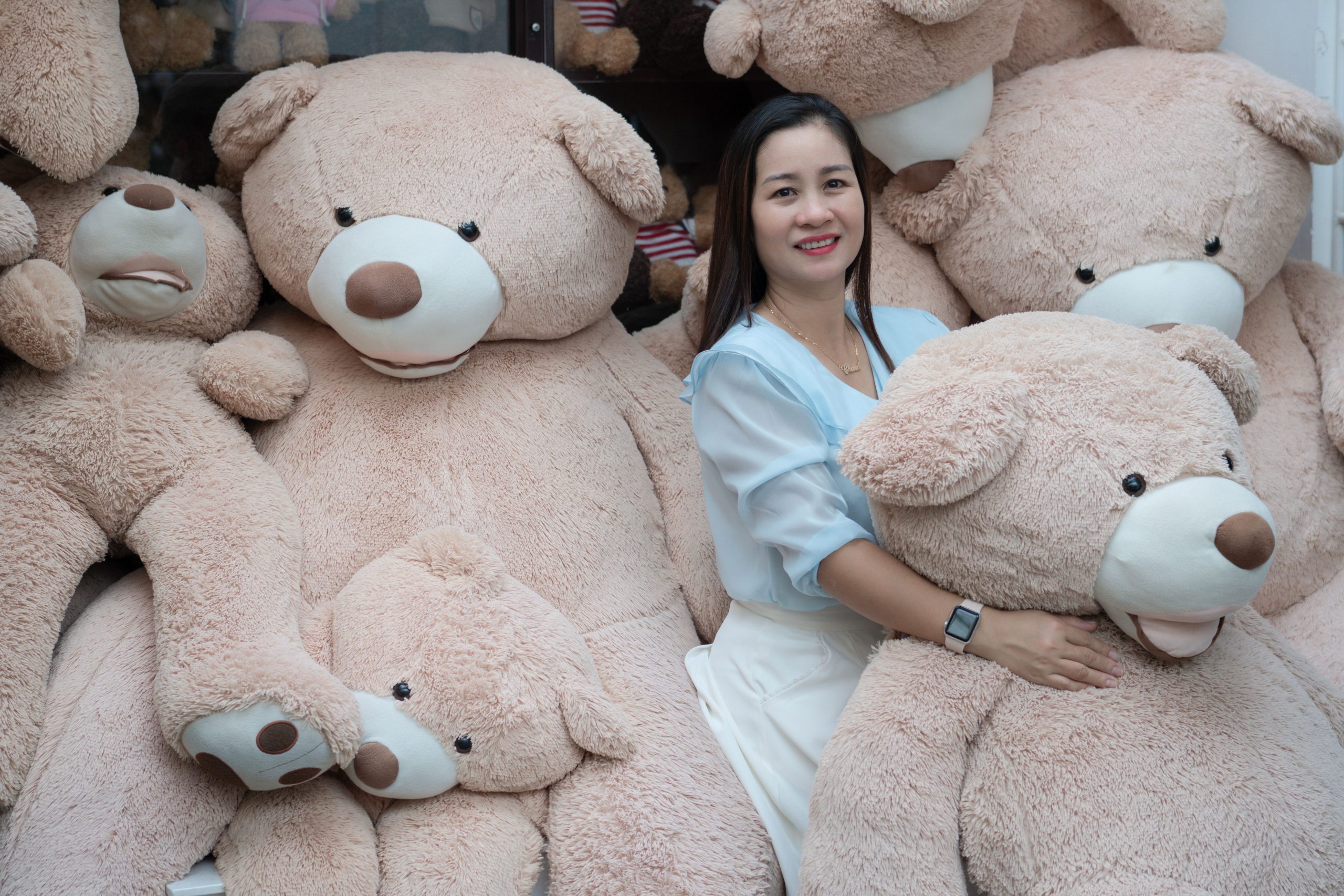 Femme souriante avec grands ours peluches confortables