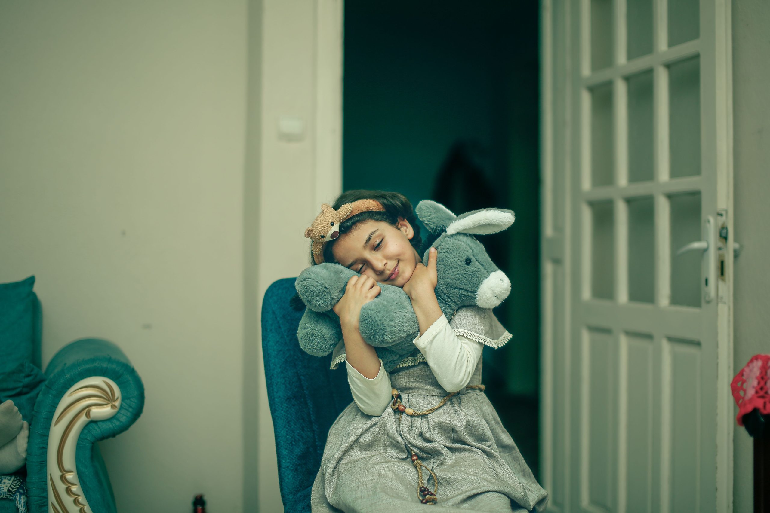 Petite fille embrassant tendrement sa peluche préférée
