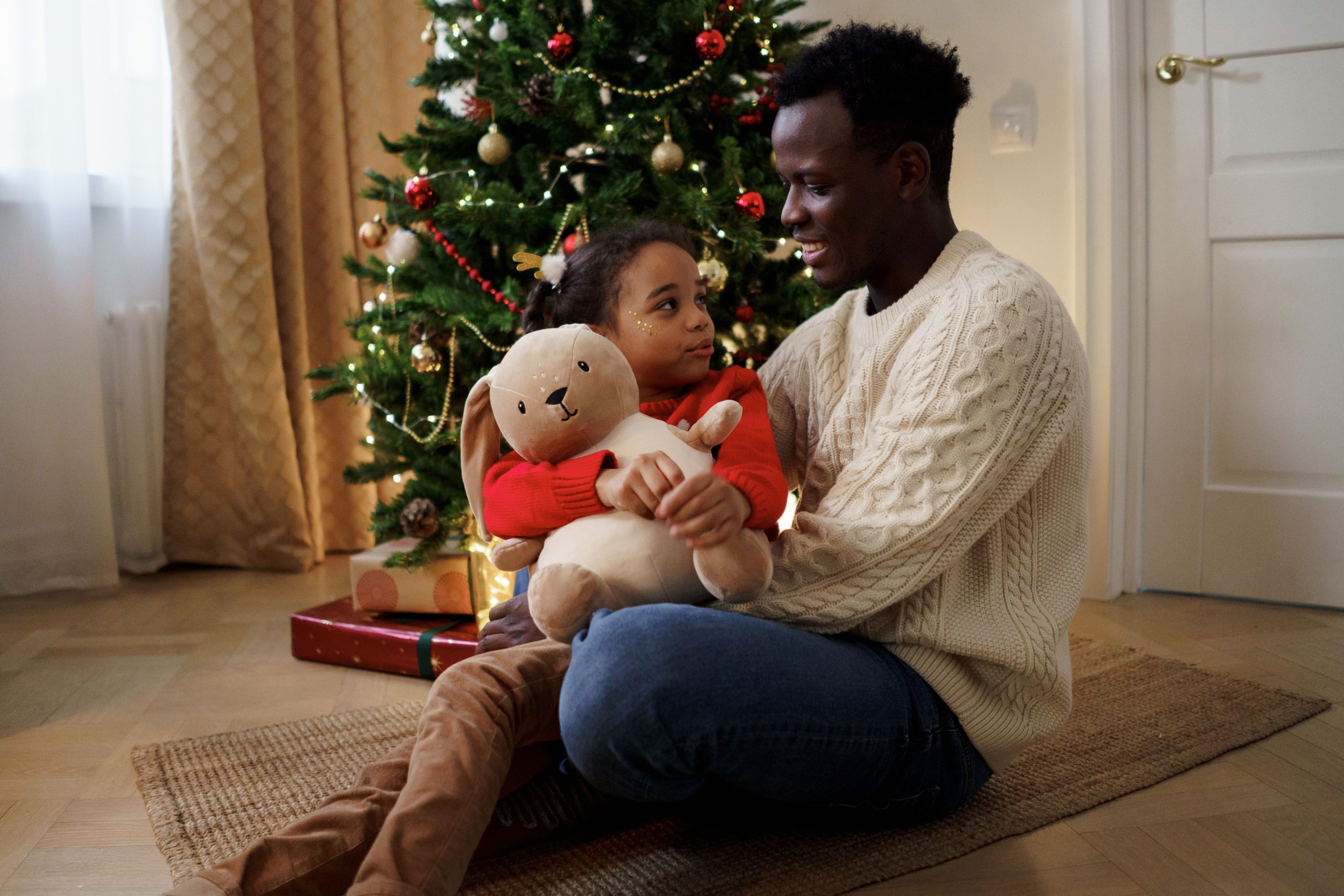 Père et fille partagent un moment peluche Noel