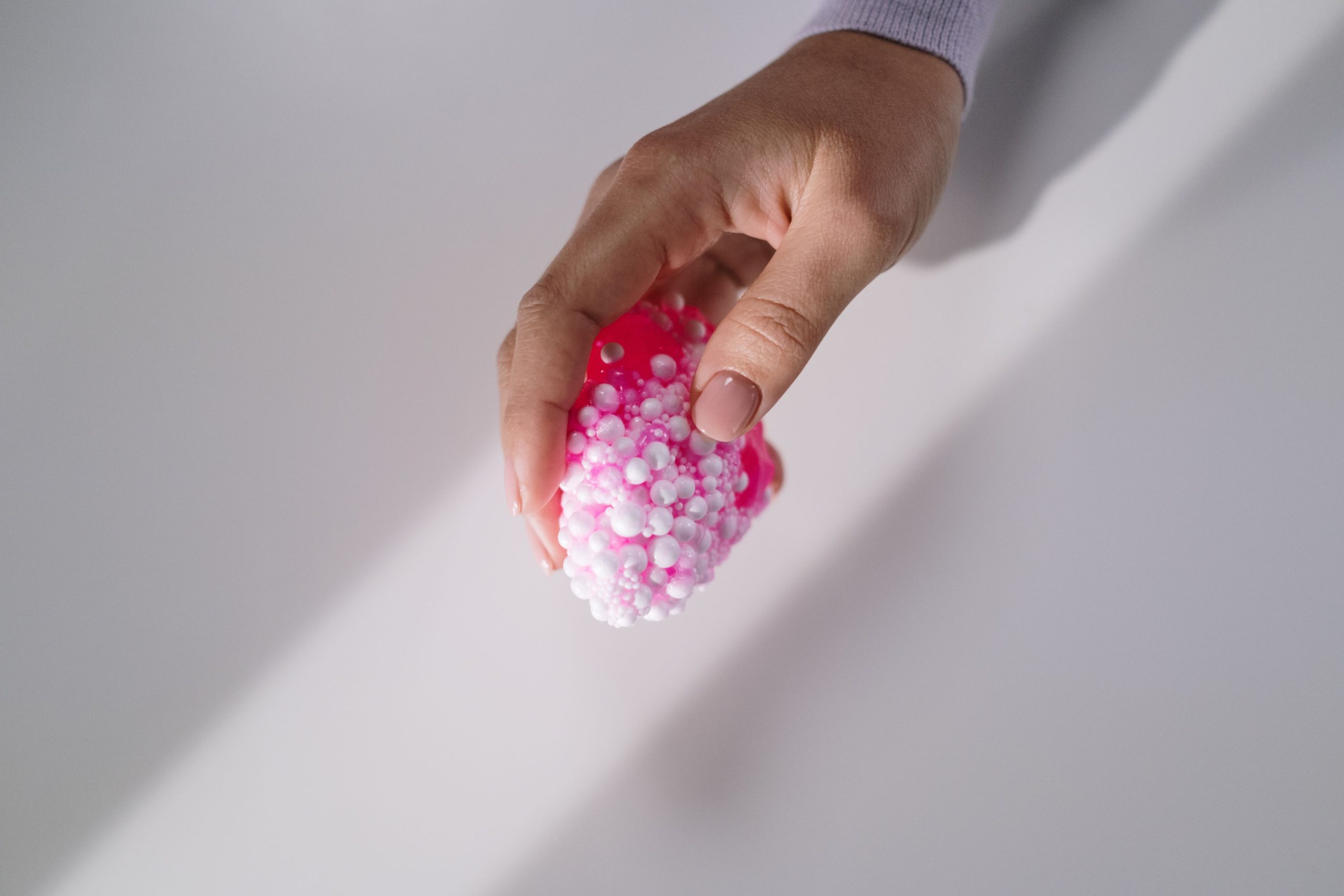 Main tenant squishy slime texturé rose