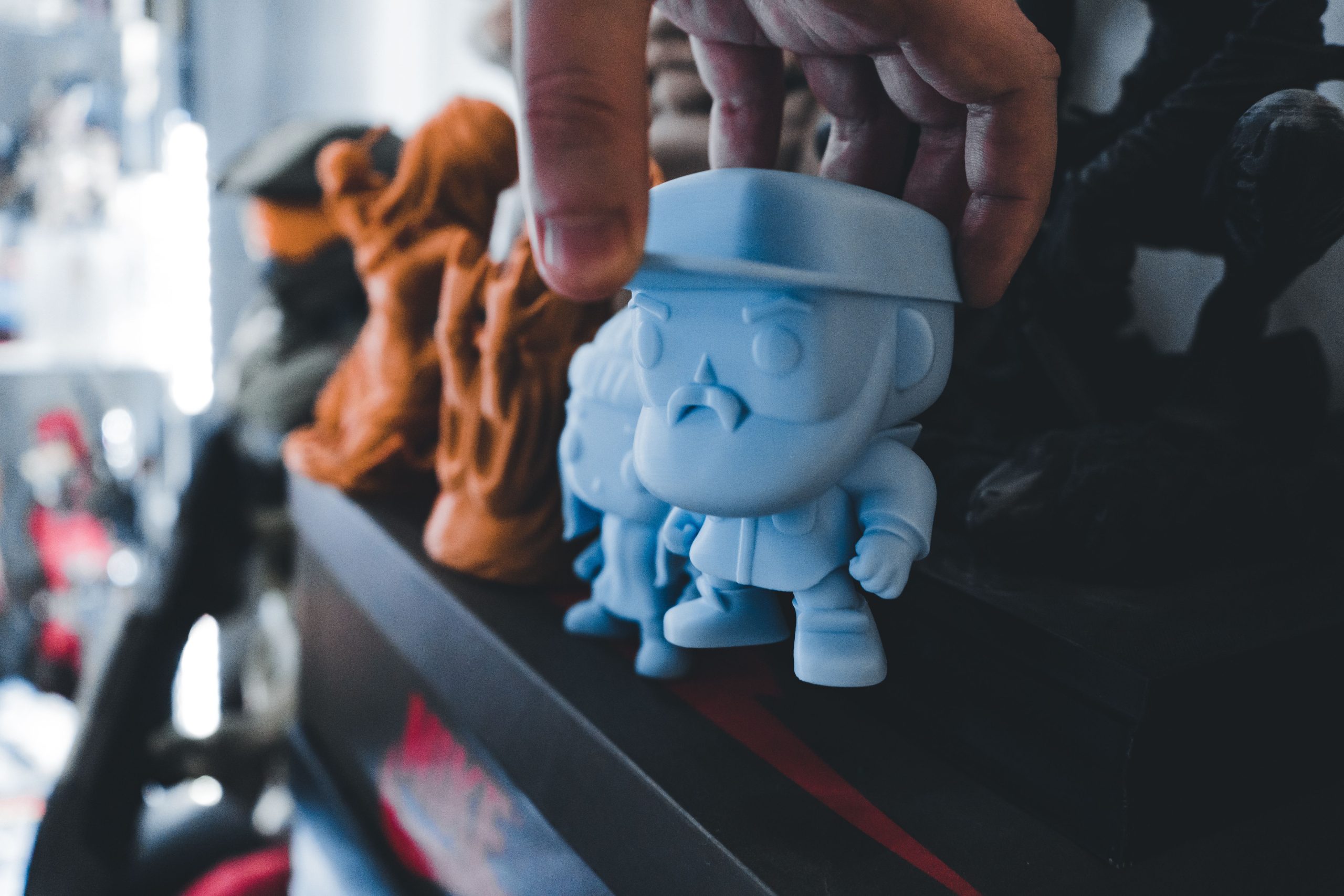 Main plaçant figurine bleue sur étagère décorée