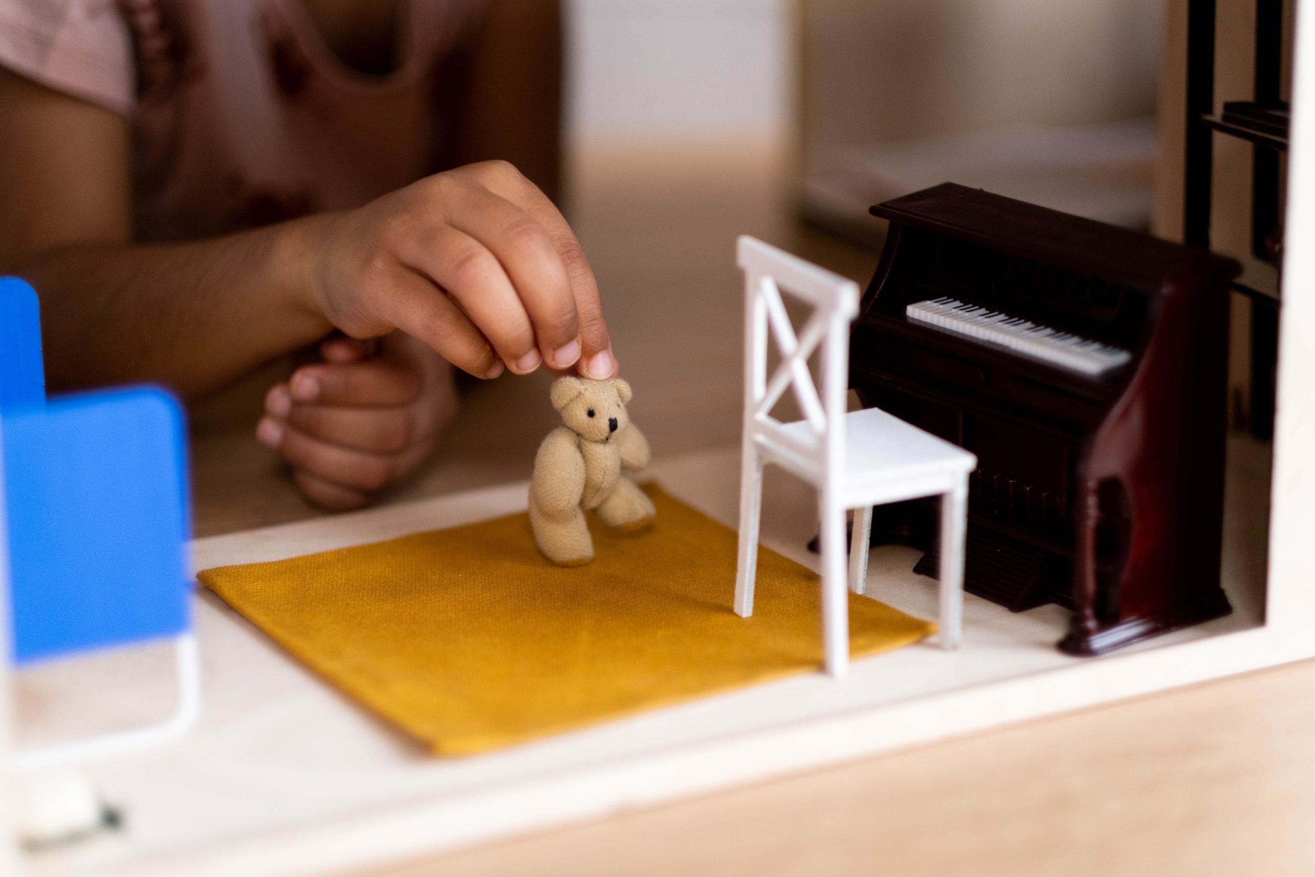 Mains enfant arrangeant jouets maison poupée piano