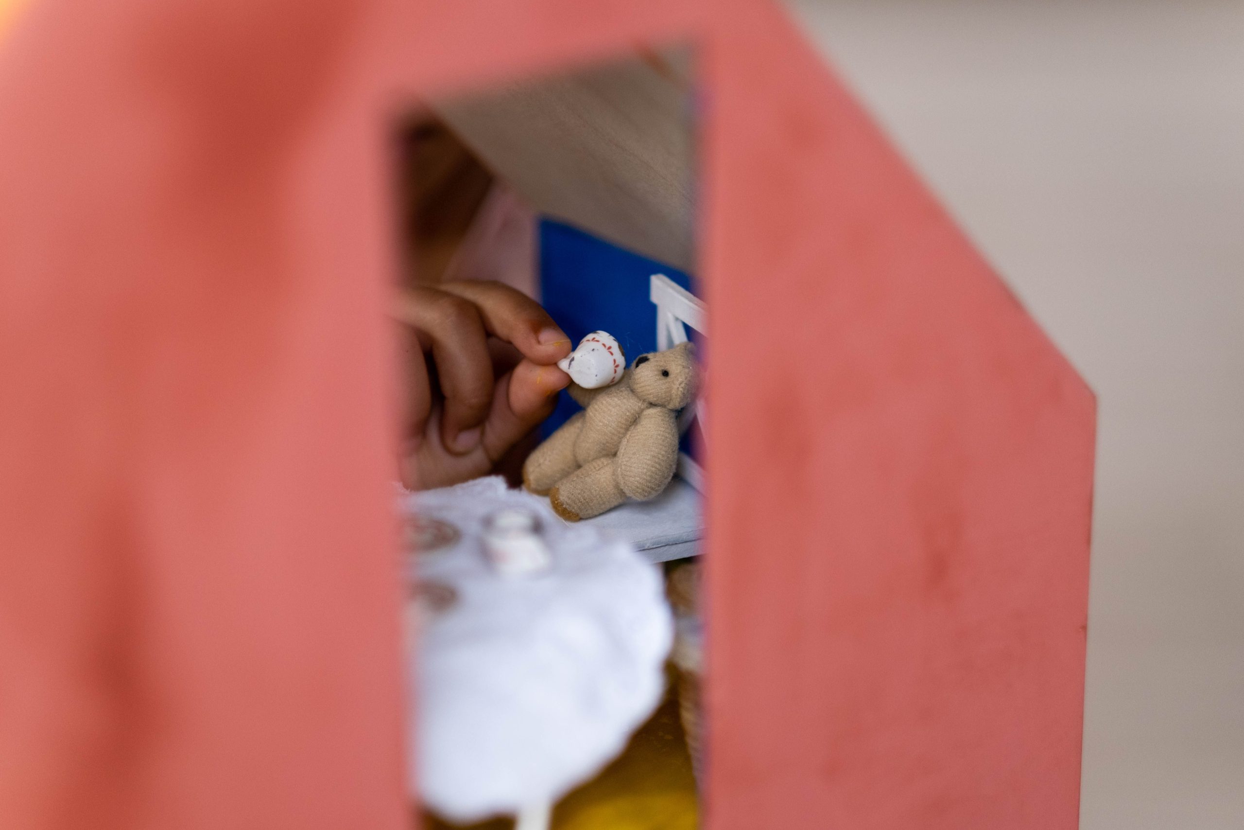 Main enfant interagissant jouets miniature maison poupée