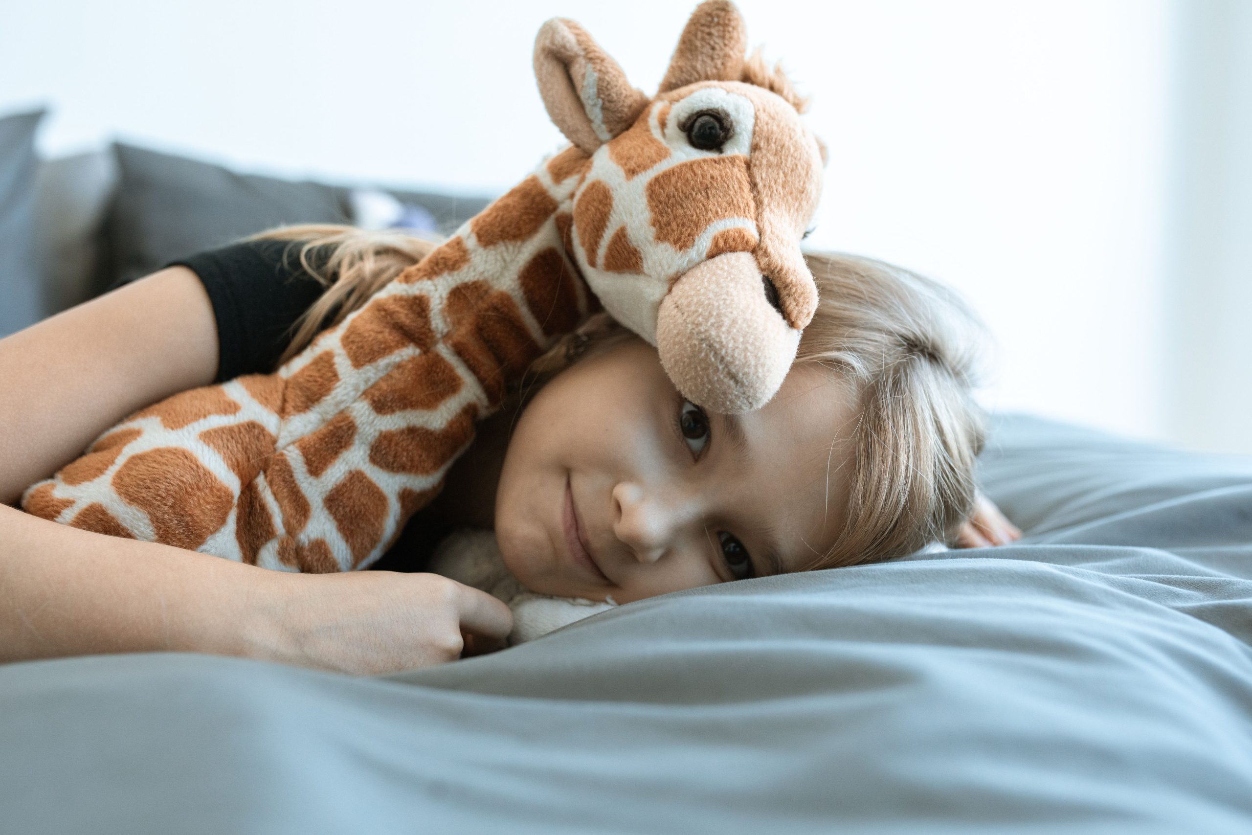 Enfant endormi serrant peluche girafe douillette